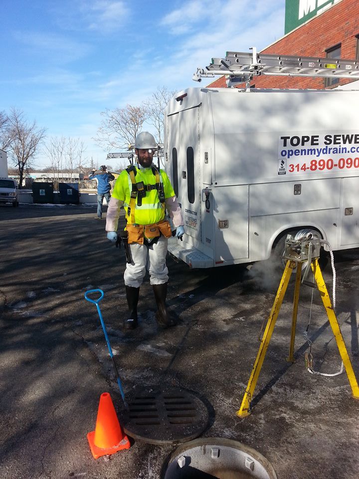 Tope Sewer hydro-jetting truck and technician working an open manhole in the St. Louis area